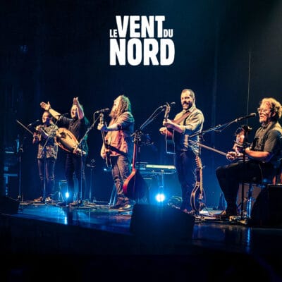 Le groupe de musique folk Le Vent du Nord se produit sur scène avec divers instruments à cordes.